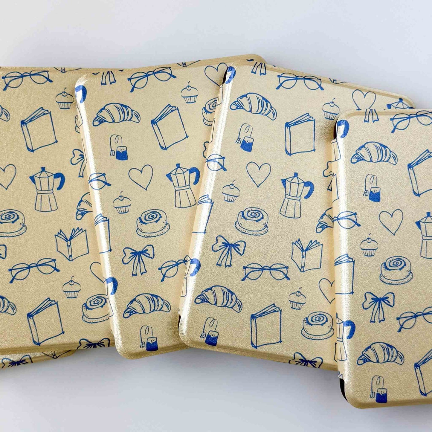 Yellow kindle cases with a blue print, fanned out on a white background 