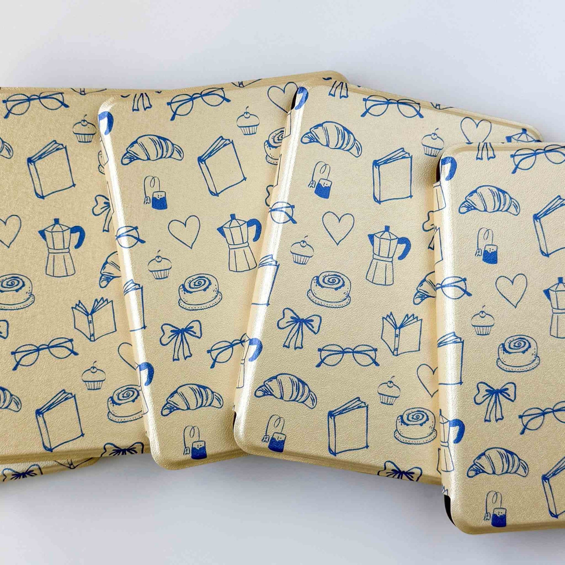 Yellow kindle cases with a blue print, fanned out on a white background 
