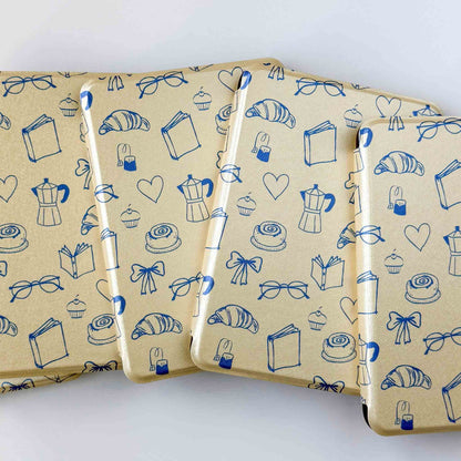 Yellow kindle cases with a blue print, fanned out on a white background 