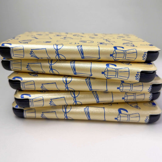 Stack of yellow kindle cases with a blue print pattern, on a white background 