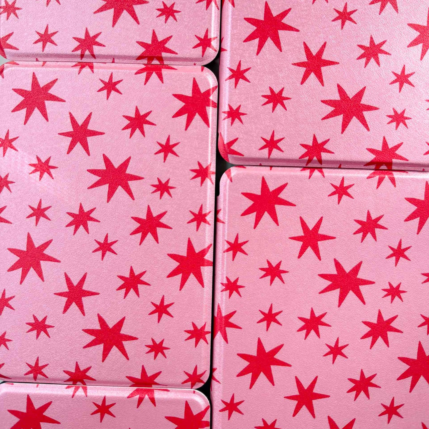 pink kindle cases printed with red stars, arranged in a tiled pattern 