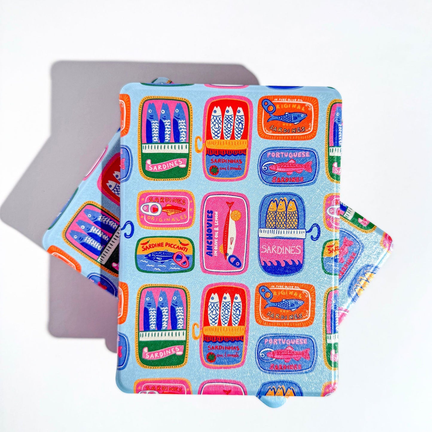 Front cover of blue kindle case with colorful sardine tins 