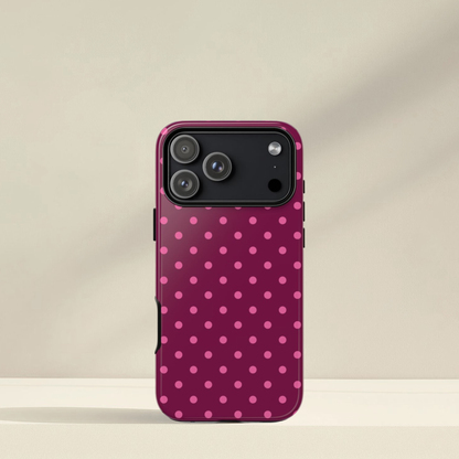 Phone case with pink polka dot pattern on a beige background