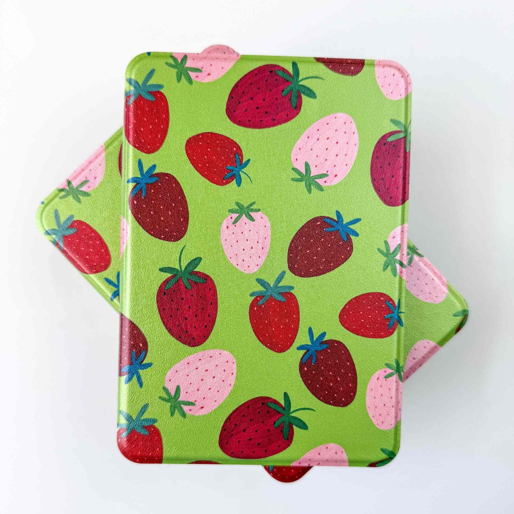 Two green kindle cases with strawberry pattern on a white background