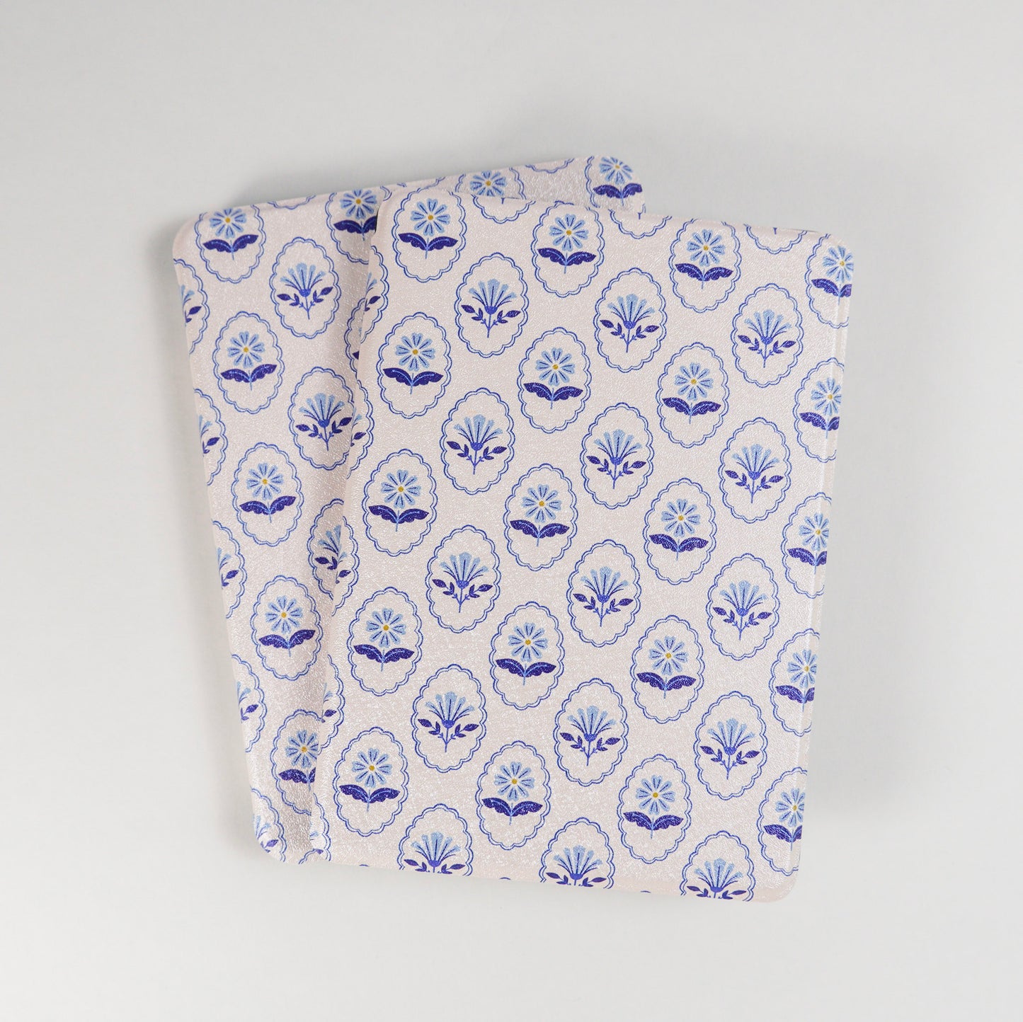 Multiple Bloom Service Kindle Cases with repeating blue floral pattern and framed flower design on beige background by Elco House