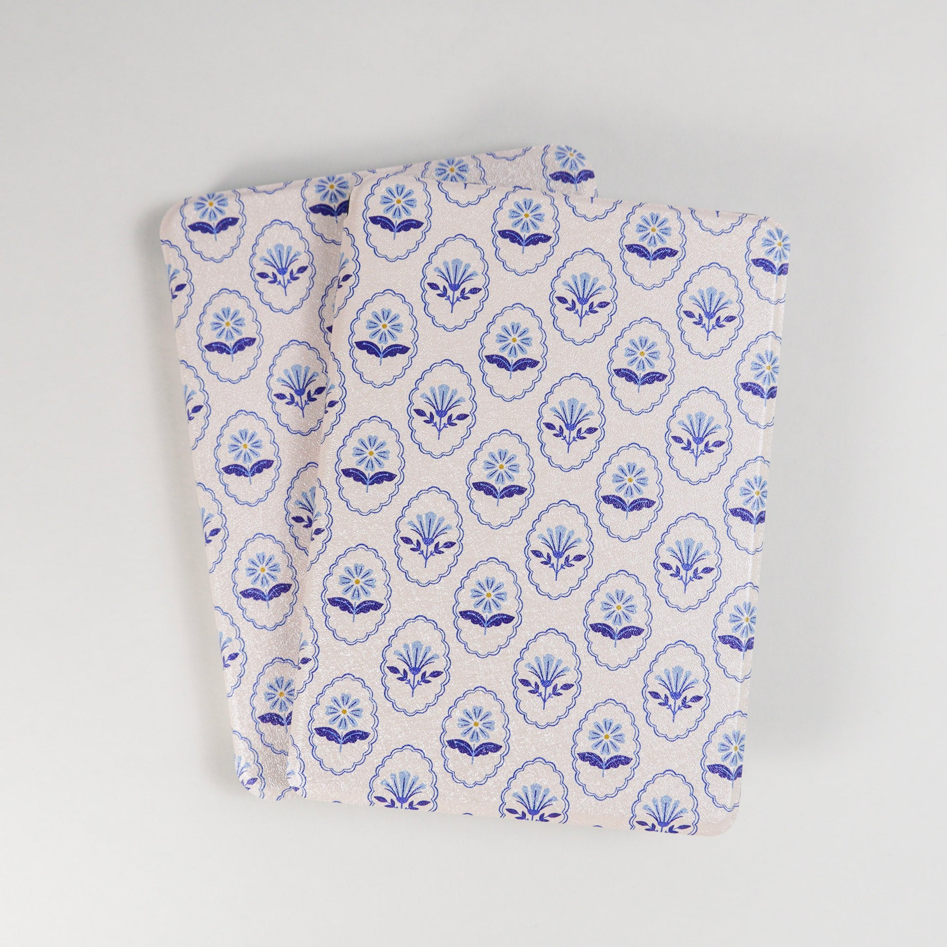 Multiple Bloom Service Kindle Cases with repeating blue floral pattern and framed flower design on beige background by Elco House