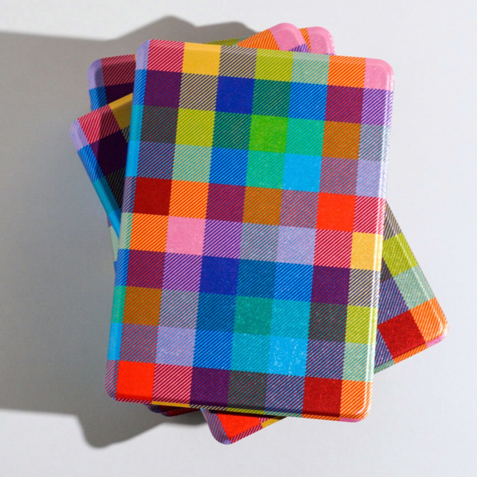 A stack of kindle case featuring a colorful madras plaid 