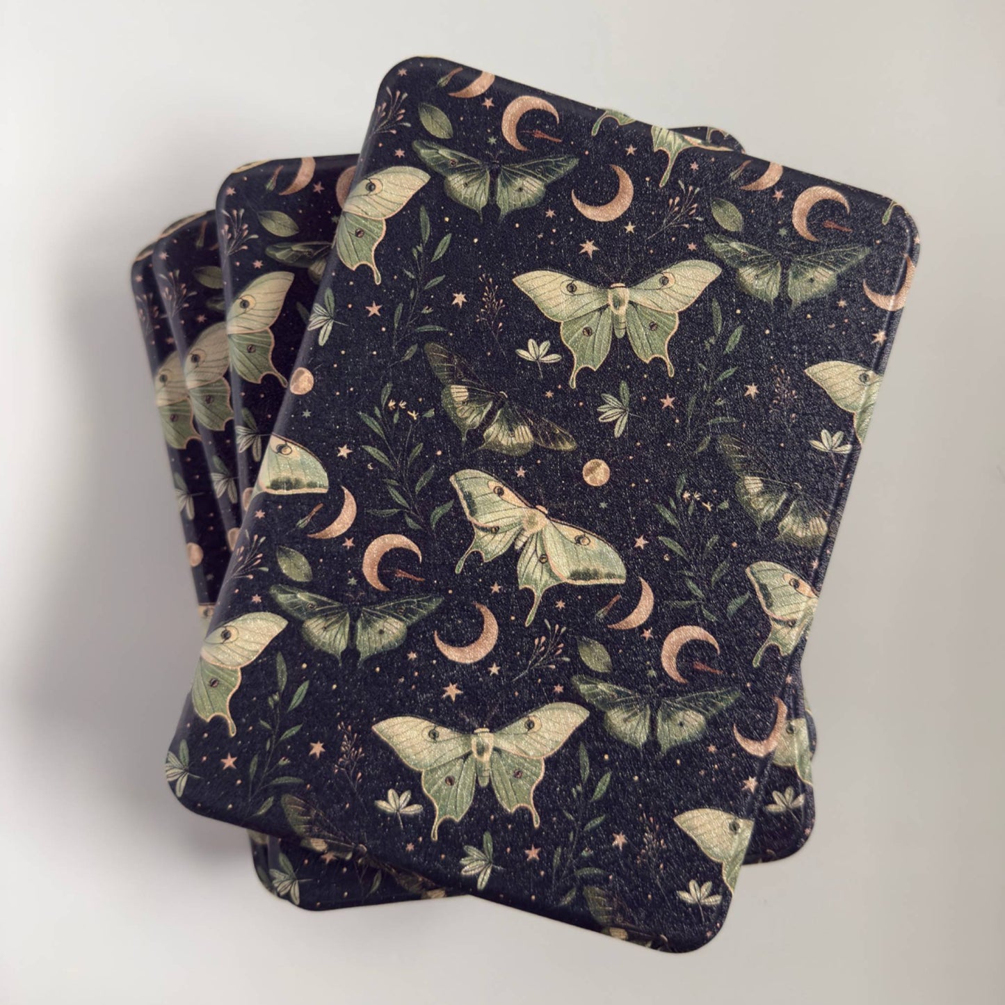 Stack of Kindle Cases with a luna moth moon design 